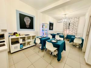 a dining room with blue tables and chairs at Maniel Beach Hotel in Letojanni