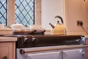 a tea kettle sitting on top of a stove in a kitchen at The Hunting Tower in Baslow +33 photos