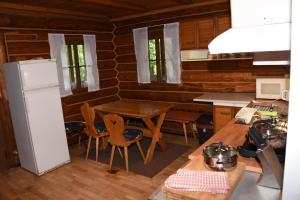 a kitchen with a table and a refrigerator at SRUB pod třešněmi - Cherry Trees Cabin in Vrchlabí