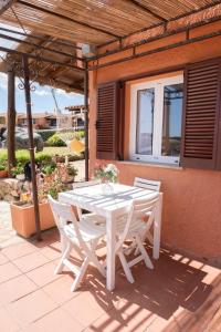 een witte tafel en stoelen op een patio bij Casa Gaia in Golfo Aranci