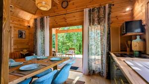a dining room with a long table and blue chairs at Le chalet de Marie in Trélissac