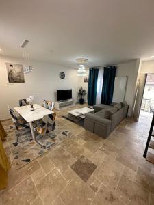 una sala de estar con un sofá y una mesa en Luxueuse Villa Neuve avec Jardin, en Colombes 24 fotos más