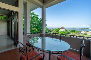 a balcony with a glass table and chairs at Aradhia Villa Nusa Dua in Nusa Dua +5 photos