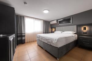 a bedroom with a large bed and a large window at Grand Taverna Boutique -Adults Only in Vama Veche