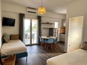 苏曼婷Vila Vera Seafront Apartments的一间有两张床、一张桌子和一间厨房的房间