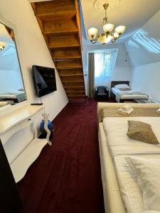 a room with two beds and a tv and a staircase at Hanu Satului in Constanţa
