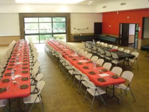 um grande salão de banquetes com mesas e cadeiras vermelhas em Cabane 3 étoiles - eed0bi em Priziac