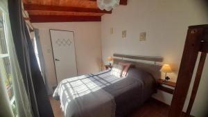 Habitación pequeña con cama y puerta en DelMar, en San Clemente del Tuyú