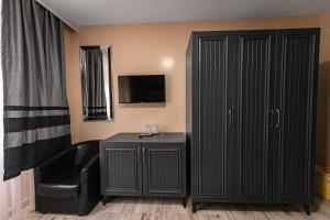a room with a black cabinet and a chair at Grand Taverna Boutique -Adults Only in Vama Veche