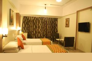 Postel nebo postele na pokoji v ubytování Nestor Hotel, Mumbai