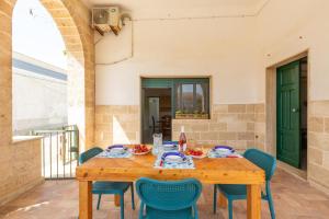 a wooden table and chairs on a patio at Villetta Stella by BarbarHouse in Torre Colimena