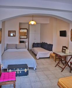 a bedroom with two beds and a couch and a table at Sunrise & Sunset apartments in Monemvasia