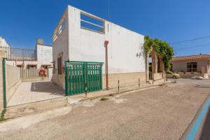 a building with a green gate on the side of a street at Villetta Stella by BarbarHouse in Torre Colimena +14 photos