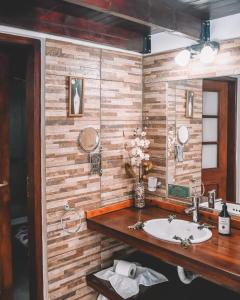 a bathroom with a sink and a wooden wall at Complejo Falda del Sauce in Villa General Belgrano