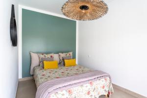 a bedroom with a bed with yellow pillows and a chandelier at Villa spacieuse et accueillante in La Roque-sur-Cèze +20 photos