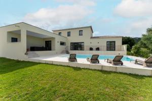 a house with a swimming pool and some chairs at Villa spacieuse et accueillante in La Roque-sur-Cèze