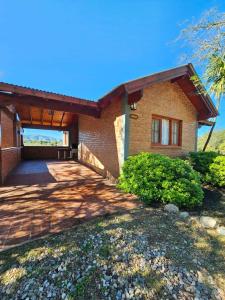a brick house with a driveway in front of it at Complejo Falda del Sauce in Villa General Belgrano