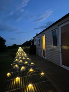 a row of lights on a deck at night at Lochview Retreat Caravan in Balminnoch