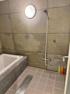 a bathroom with a tub and a shower with a light at Hotel Be-zen shimanouchi in Osaka +37 photos