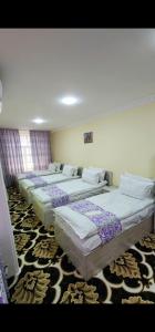 eine Reihe von Betten in einem Zimmer in der Unterkunft Guest House Rayhona in Samarkand