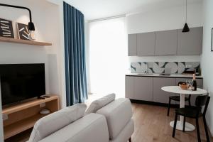 a living room with a white couch and a table at Paramar Casa Vacanza Conversano in Conversano