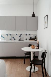 a white kitchen with a white table and chairs at Paramar Casa Vacanza Conversano in Conversano