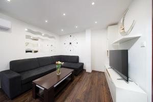 Mali DolにあるHoliday House Milaのリビングルーム(黒いソファ、テレビ付)