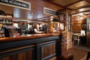 a man standing behind a bar in a restaurant at The Seaton Lane Inn - The Inn Collection Group in Seaham