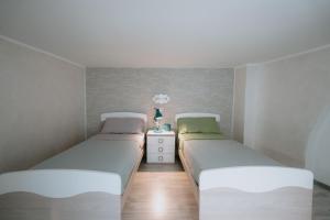 two beds in a small bedroom with white walls at Le Vele Apartment San Salvo Marina in Marina di Montenero