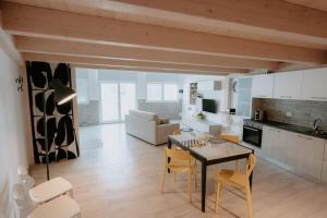 a kitchen and living room with a table and chairs at Le Vele Apartment San Salvo Marina in Marina di Montenero