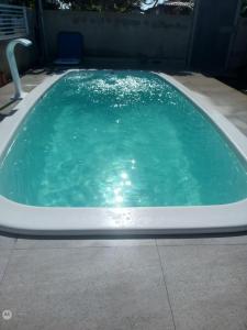 a large pool of green water in a backyard at Paraíso a Beira Mar in Praia Da Caueira