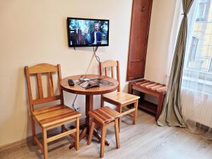 a room with a table and chairs and a tv at DReAM Post Aparthotel in Kraków
