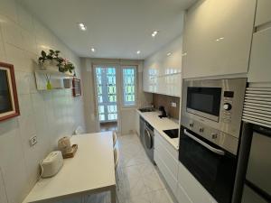 a kitchen with a sink and a stove top oven at Playa de los Locos con Garaje Recién Reformado!! in Suances +20 photos