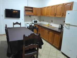a kitchen with a table and a refrigerator at CASA CENTRO Avenida Peron in La Rioja
