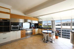 a large kitchen with a table and a large window at Atlantic Sky Penthouses 3-Bedroom and Studio with Breathtaking Views in Cape Town