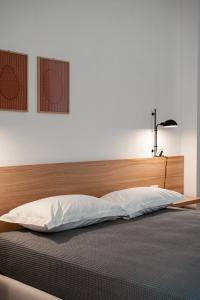 a large bed with a wooden headboard and a lamp at Paramar Casa Vacanza Conversano in Conversano