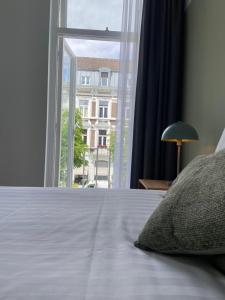 a bedroom with a bed and a large window at Alex Maastricht in Maastricht