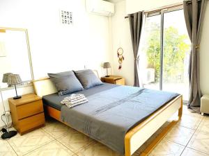 una camera da letto con un letto e una grande finestra di Villa 4 rooms clim, à pied plage a Mauguio