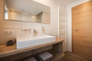 a bathroom with a white sink and a mirror at Appartements Markus in Fiss +29 photos