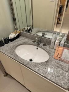 a bathroom counter with a sink and a mirror at Hotel Be-zen shimanouchi in Osaka