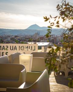 a balcony with chairs and a view of a city at B&B HOTEL Clermont-Ferrand A71-A75 La M&eacute;ridienne in Clermont-Ferrand