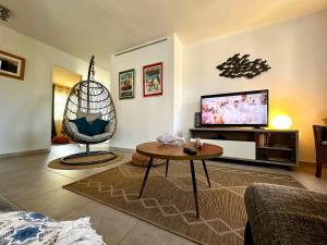 a living room with a table and a tv at CASSIS VILLAGE Options Parking and Baby in Cassis