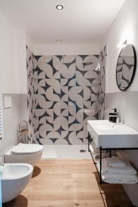 a bathroom with two sinks and a geometric wall at Paramar Casa Vacanza Conversano in Conversano