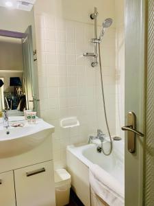 a bathroom with a tub and a sink and a shower at H&ocirc;tel du Roy in Aisey-sur-Seine