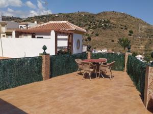 a patio with a table and chairs on a balcony at Casa El Barco in Torrox