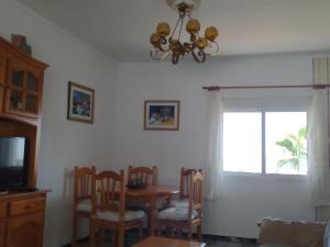 a dining room with a table and chairs and a window at Casa El Barco in Torrox