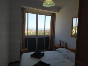 a bedroom with two beds and a large window at Casa El Barco in Torrox