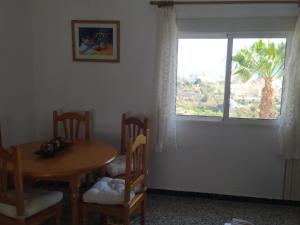 a dining room with a table and chairs and a window at Casa El Barco in Torrox