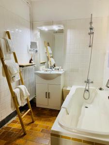 a bathroom with a bath tub and a sink and a bath tub at H&ocirc;tel du Roy in Aisey-sur-Seine