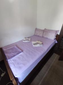 a bed in a room with purple sheets and pillows at Mercury Guest House in Veliko Tŭrnovo